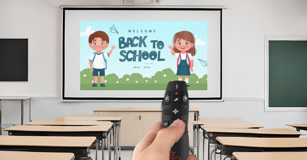 Teacher using a presentation clicker to control a 'Back to School' slideshow in a classroom with empty desks.